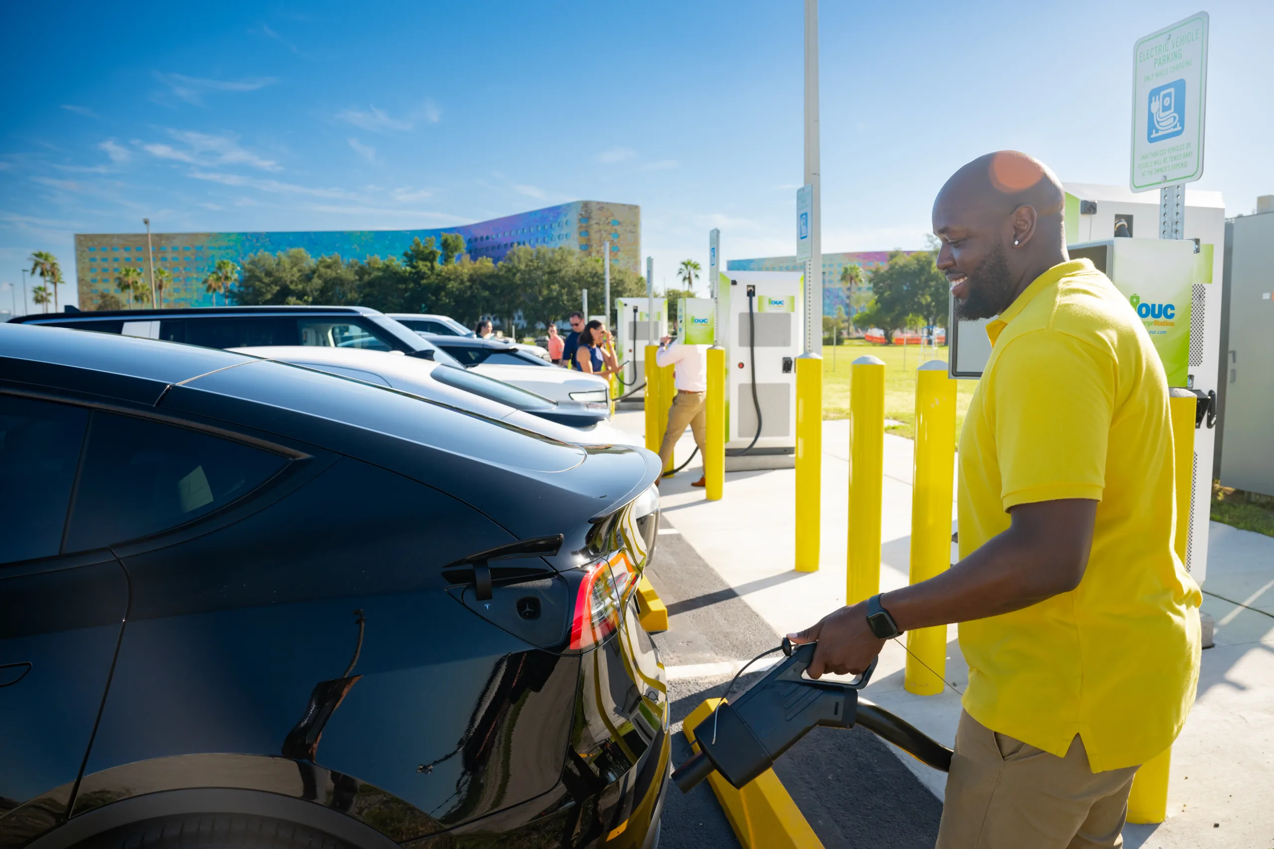 Man charging EV at OUC charging station