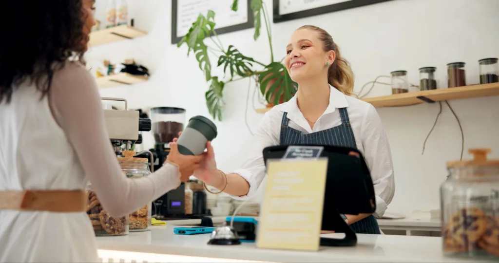 Barista serving coffee to a customer