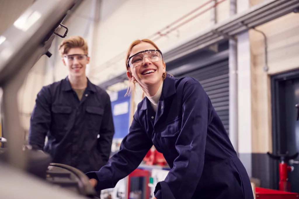 Two auto mechanics working near a car