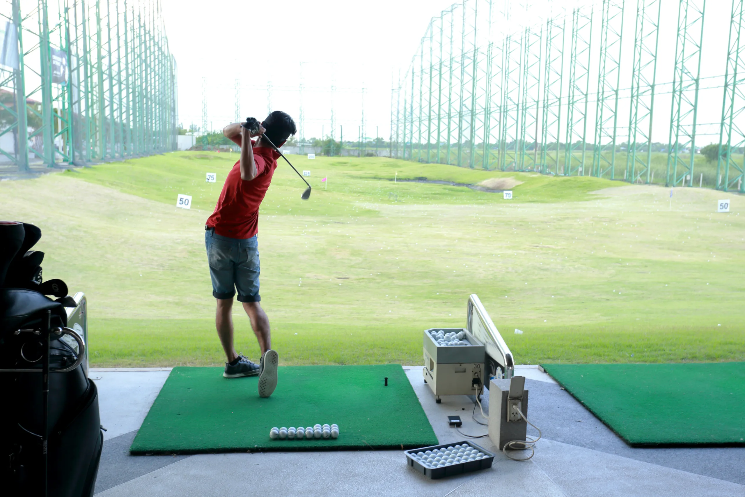Teen golfer at a golf driving range